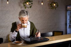 ?lterer Mann unter Verwendung des Laptops und des haben Kaffees in der Bar stockfotografie ?lterer Mann unter Verwendung des Laptops und des haben Kaffees in der Bar stockfotografie