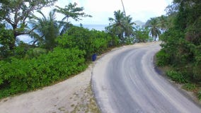 Luchtmening die van Auto onderaan de Weg dichtbij het Strand, Seychellen overgaan stock footage Luchtmening die van Auto onderaan de Weg dichtbij het Strand, Seychellen overgaan stock footage