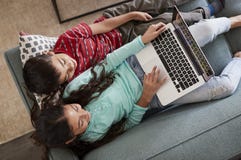 Luchtmening van Broer And Sister Sitting bij Sofa At Home Having Fun-het Spelen op Laptop samen stock afbeeldingen Luchtmening van Broer And Sister Sitting bij Sofa At Home Having Fun-het Spelen op Laptop samen stock afbeeldingen