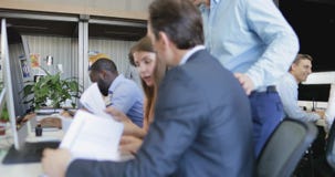 Ludzie biznesu siedzi przy komputerem w nowożytnym biurze studiują papiery, drużynowy analizuje dane raporty, biznesmeni i zdjęcie wideo Ludzie biznesu siedzi przy komputerem w nowożytnym biurze studiują papiery, drużynowy analizuje dane raporty, biznesmeni i zdjęcie wideo