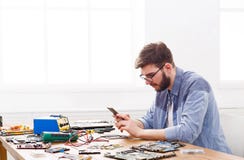Luie hersteller het spelen smartphone in werkplaats royalty-vrije stock fotografie Luie hersteller het spelen smartphone in werkplaats royalty-vrije stock fotografie