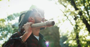 Lumberjack стоя с его осью в древесинах, смотря вокруг Портрет красивого бородатого человека с осью видеоматериал Lumberjack стоя с его осью в древесинах, смотря вокруг Портрет красивого бородатого человека с осью видеоматериал