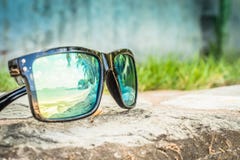 Lunettes de soleil ? la mode Lunettes de soleil avec les lentilles refl?t?es R?flexion de la plage et des palmiers tropicaux dans photo libre de droits Lunettes de soleil ? la mode Lunettes de soleil avec les lentilles refl?t?es R?flexion de la plage et des palmiers tropicaux dans photo libre de droits