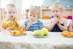 Lustige Kinder des Baums, die Früchte in der Tagesstätte essen lizenzfreies stockfoto Lustige Kinder des Baums, die Früchte in der Tagesstätte essen lizenzfreies stockfoto