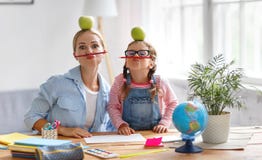 Lustige Mutter- und Kindertochter, die Hausarbeit Schreiben und readi tut lizenzfreie stockbilder Lustige Mutter- und Kindertochter, die Hausarbeit Schreiben und readi tut lizenzfreie stockbilder