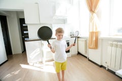 Lustiges europ?isches Cheftanzen des kleinen Jungen, gl?ckliches Wochenende, Junge m?chte Pfannkuchen machen, aber die Bratpfanne lizenzfreies stockfoto Lustiges europ?isches Cheftanzen des kleinen Jungen, gl?ckliches Wochenende, Junge m?chte Pfannkuchen machen, aber die Bratpfanne lizenzfreies stockfoto