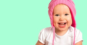 Lustiges glückliches Baby in einem rosa Winterstrickmützelachen stockfotos Lustiges glückliches Baby in einem rosa Winterstrickmützelachen stockfotos