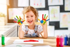 Lustiges Kindermädchen zeichnet die lachenden Showhände, die mit Farbe schmutzig sind lizenzfreies stockfoto Lustiges Kindermädchen zeichnet die lachenden Showhände, die mit Farbe schmutzig sind lizenzfreies stockfoto