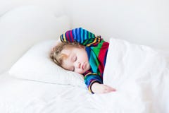 Lustiges Kleinkindmädchen, das in einem weißen Bett schläft stockbilder Lustiges Kleinkindmädchen, das in einem weißen Bett schläft stockbilder