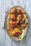 Lustrata piccante ed il bacon hanno avvolto le coscie di pollo al forno con le cipolle ed il peperoncino rosso fotografia stock libera da diritti Lustrata piccante ed il bacon hanno avvolto le coscie di pollo al forno con le cipolle ed il peperoncino rosso fotografia stock libera da diritti