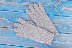Luvas femininos de lã para o outono ou o inverno em placas azuis idosas imagem de stock Luvas femininos de lã para o outono ou o inverno em placas azuis idosas imagem de stock