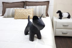 Luxury modern style bedroom with toy black dog and different pillows on white bed, Interior of a hotel bedroom stock photos Luxury modern style bedroom with toy black dog and different pillows on white bed, Interior of a hotel bedroom stock photos