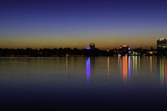 Luzes da cidade que refletem na noite sobre a água do lago Herastrau imagens de stock Luzes da cidade que refletem na noite sobre a água do lago Herastrau imagens de stock