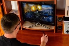 LVIV, UKRAINE - 8 MARS 2019 : Illustration d'un monde de jeu d'ordinateur des réservoirs, montrant un homme jouant ce jeu images libres de droits LVIV, UKRAINE - 8 MARS 2019 : Illustration d'un monde de jeu d'ordinateur des réservoirs, montrant un homme jouant ce jeu images libres de droits