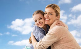 Lycklig familj av flickan och modern som kramar över himmel arkivbilder Lycklig familj av flickan och modern som kramar över himmel arkivbilder