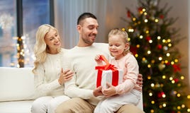 Lycklig familj hemma med julgåvan royaltyfri bild Lycklig familj hemma med julgåvan royaltyfri bild