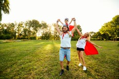 Lycklig familj i dräkter av superheroes i parkera på solnedgången fotografering för bildbyråer Lycklig familj i dräkter av superheroes i parkera på solnedgången fotografering för bildbyråer