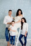 Lycklig familj med gravida kvinnan och barn som poserar i studion arkivfoto Lycklig familj med gravida kvinnan och barn som poserar i studion arkivfoto