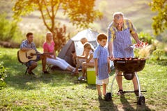 Lycklig familj som campar och gör bbq royaltyfria foton Lycklig familj som campar och gör bbq royaltyfria foton