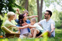 Lycklig familj som tycker om picknicken i natur på sommar arkivfoto Lycklig familj som tycker om picknicken i natur på sommar arkivfoto