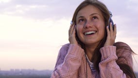 Lycklig flicka som lyssnar till musik med hörlurar som står på taket fotografering för bildbyråer Lycklig flicka som lyssnar till musik med hörlurar som står på taket fotografering för bildbyråer