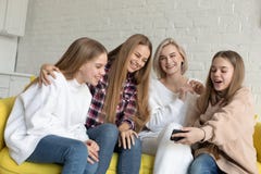 Lycklig h?rlig lesbisk familj i tillf?llig kl?der hemma som sitter p? den gula soffan, medan g?ra selfie royaltyfri foto Lycklig h?rlig lesbisk familj i tillf?llig kl?der hemma som sitter p? den gula soffan, medan g?ra selfie royaltyfri foto