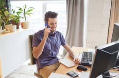 Lycklig idérik manlig arbetare som kallar på smarphone arkivfoton Lycklig idérik manlig arbetare som kallar på smarphone arkivfoton