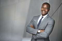 Lycklig le stående av en lyckad säker man för affär för företags ledare för afrikansk amerikan arkivbild Lycklig le stående av en lyckad säker man för affär för företags ledare för afrikansk amerikan arkivbild