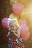 Lycklig liten blond caucasian flicka utanför med ballonger arkivbild Lycklig liten blond caucasian flicka utanför med ballonger arkivbild