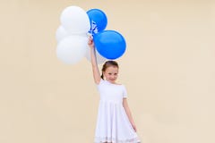 Lycklig liten flicka med bl?a och vita ballonger royaltyfri bild Lycklig liten flicka med bl?a och vita ballonger royaltyfri bild