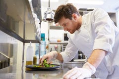 Lycklig manlig kockmatlagningmat på restaurangkök arkivfoto Lycklig manlig kockmatlagningmat på restaurangkök arkivfoto