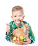 Lycklig pojke med easter ägg som omfamnar kanin och visar upp tummar bakgrund isolerad white Royaltyfri Foto Lycklig pojke med easter ägg som omfamnar kanin och visar upp tummar bakgrund isolerad white Royaltyfri Foto