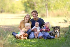 Lycklig skratta familj av 5 personer och hund i Sunny Garden arkivbild Lycklig skratta familj av 5 personer och hund i Sunny Garden arkivbild