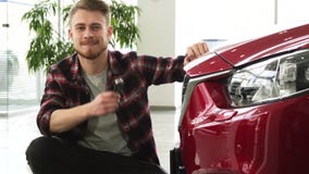 Lycklig stilig man som poserar med hans nya biltangenter för auto visning till kameran lager videofilmer Lycklig stilig man som poserar med hans nya biltangenter för auto visning till kameran lager videofilmer