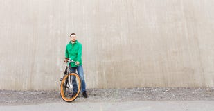 Lycklig ung hipsterman med den fasta kugghjulcykeln royaltyfri fotografi Lycklig ung hipsterman med den fasta kugghjulcykeln royaltyfri fotografi