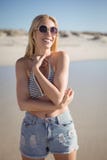 Lyckliga bärande sunglasss för ung kvinna på stranden royaltyfri foto Lyckliga bärande sunglasss för ung kvinna på stranden royaltyfri foto