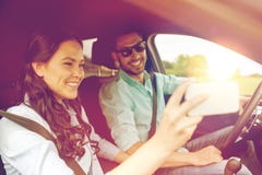 Lyckliga par i bilen som tar selfie med smartphonen royaltyfria bilder Lyckliga par i bilen som tar selfie med smartphonen royaltyfria bilder