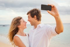 Lyckliga romantiska par på stranden som tar fotoet royaltyfria bilder Lyckliga romantiska par på stranden som tar fotoet royaltyfria bilder