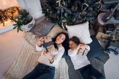 Lyckliga öppnande julgåvor för moder och för dotter Familjen samlade runt om ett träd hemma Julgran med presents arkivfoton Lyckliga öppnande julgåvor för moder och för dotter Familjen samlade runt om ett träd hemma Julgran med presents arkivfoton