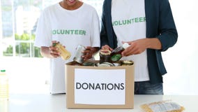 Lyckligt volontärlag som packar en matdonationask lager videofilmer Lyckligt volontärlag som packar en matdonationask lager videofilmer