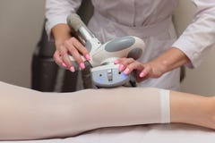 Lymphatic drainage massage LPG apparatus process. Woman in white suit getting anti cellulite massage in a beauty SPA salon. LPG, royalty free stock image Lymphatic drainage massage LPG apparatus process. Woman in white suit getting anti cellulite massage in a beauty SPA salon. LPG, royalty free stock image