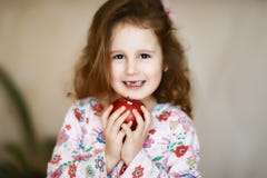 Lächeln und Griffe eines süßes kleines gelocktes zahnlos Mädchens in ihren Palmen ein roter Apfel, der Milchzähne verloren hat stockbild Lächeln und Griffe eines süßes kleines gelocktes zahnlos Mädchens in ihren Palmen ein roter Apfel, der Milchzähne verloren hat stockbild