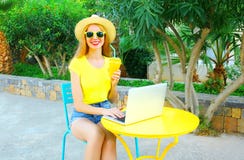 lächelnde Frau arbeitet unter Verwendung einer Laptop-Computers sitzt an einem Café Lizenzfreie Stockfotografie lächelnde Frau arbeitet unter Verwendung einer Laptop-Computers sitzt an einem Café Lizenzfreie Stockfotografie