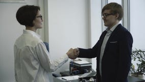 Lächelnde Geschäftsleute, die Hände in ihrem Büro rütteln Lächelnder Geschäftsmann unter Verwendung des Laptop cmputer am Schreib stock video footage Lächelnde Geschäftsleute, die Hände in ihrem Büro rütteln Lächelnder Geschäftsmann unter Verwendung des Laptop cmputer am Schreib stock video footage