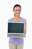 Lächelnde junge Frau, die ihren Laptop zeigt lizenzfreies stockbild Lächelnde junge Frau, die ihren Laptop zeigt lizenzfreies stockbild