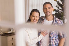 Lächelnde Paare, die nahe dem Weihnachtsbaum streicheln lizenzfreie stockfotos Lächelnde Paare, die nahe dem Weihnachtsbaum streicheln lizenzfreie stockfotos