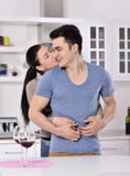 Lächelnde Paare, die rote Rebe im kitchev genießen stockfoto Lächelnde Paare, die rote Rebe im kitchev genießen stockfoto