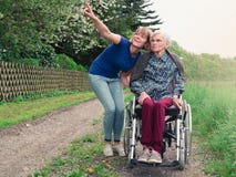 Lächelnde Tochter und Großmutter mit Rollstuhl lizenzfreies stockfoto Lächelnde Tochter und Großmutter mit Rollstuhl lizenzfreies stockfoto