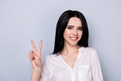 Lächelnder netter Brunette gestikuliert das Zeichen mit zwei Fingern Sie ist Abnutzung lizenzfreies stockbild Lächelnder netter Brunette gestikuliert das Zeichen mit zwei Fingern Sie ist Abnutzung lizenzfreies stockbild