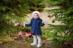 Lächelndes kleines Mädchen des Weihnachtsporträts Kinderin rotem nahem Baum Sankt lizenzfreies stockfoto Lächelndes kleines Mädchen des Weihnachtsporträts Kinderin rotem nahem Baum Sankt lizenzfreies stockfoto